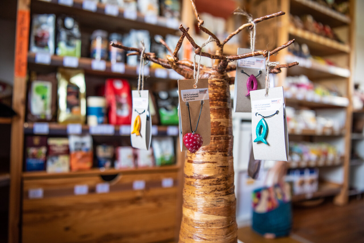 Foto aus dem Weltladen Stein zeigt Regal mit fairem Kaffee und im Vordergrund fairen Schmuck.